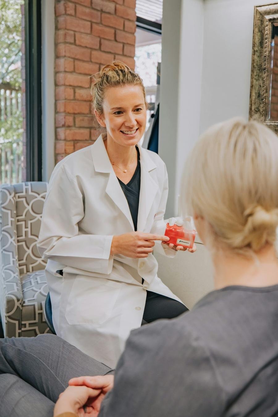Dentista conversando com paciente no consultório