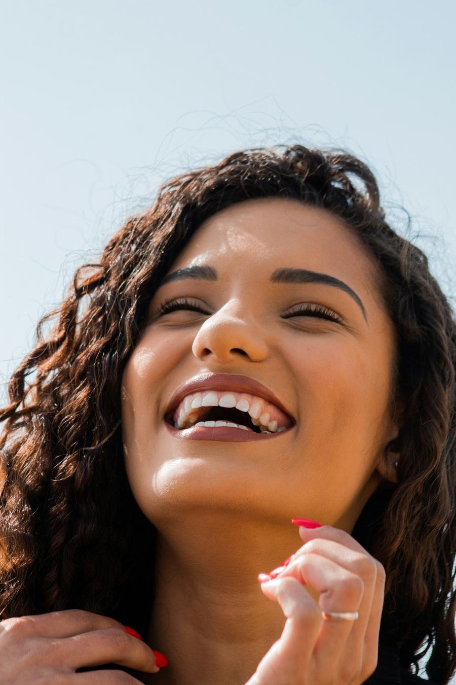Mulher sorrindo com a mão no rosto