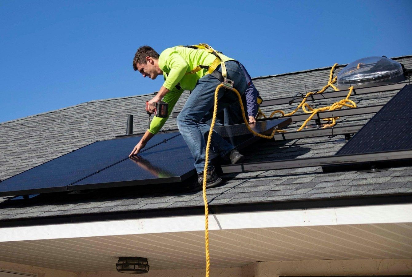 Instalador fixando placas solares em um telhado